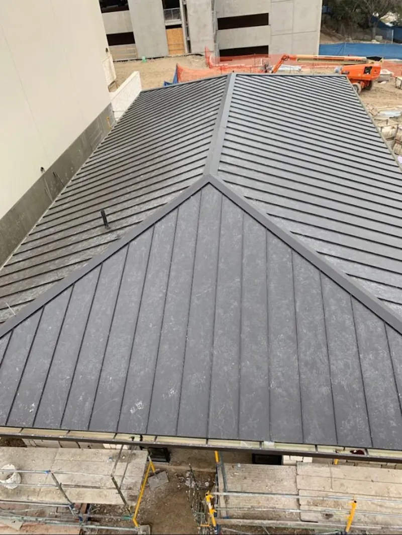 Commercial metal roof construction with crane equipment in Atascadero